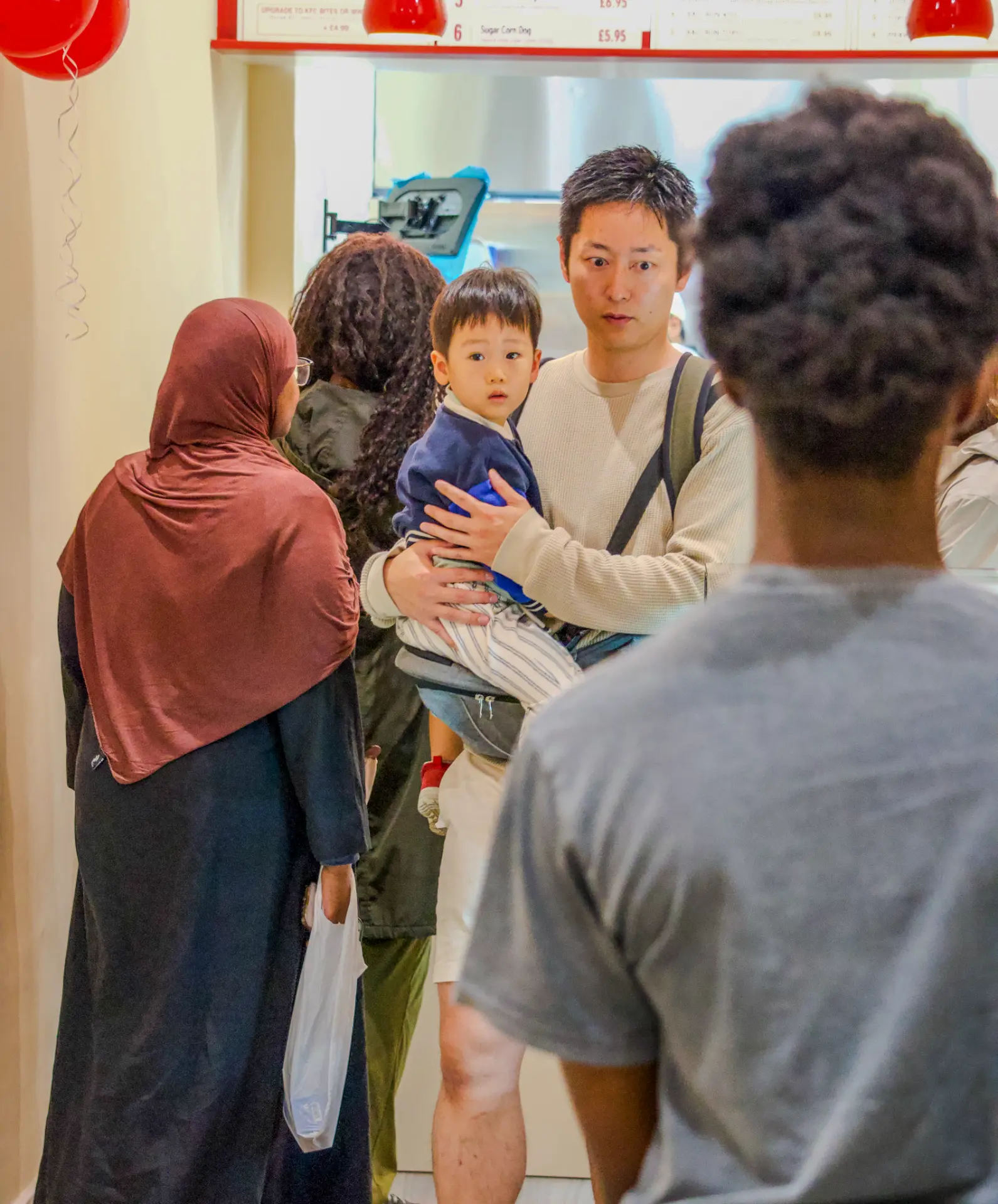 Family waiting for their order under the Kimabi corn dog menu